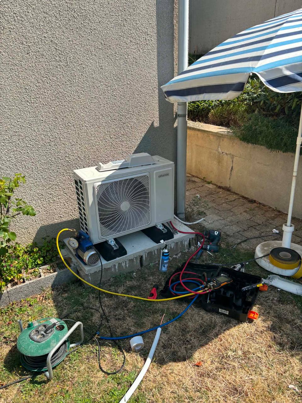 Mise en service d'une climatisation Atlantic par Happy Confort — unité extérieure sur socle, tirage au vide en cours